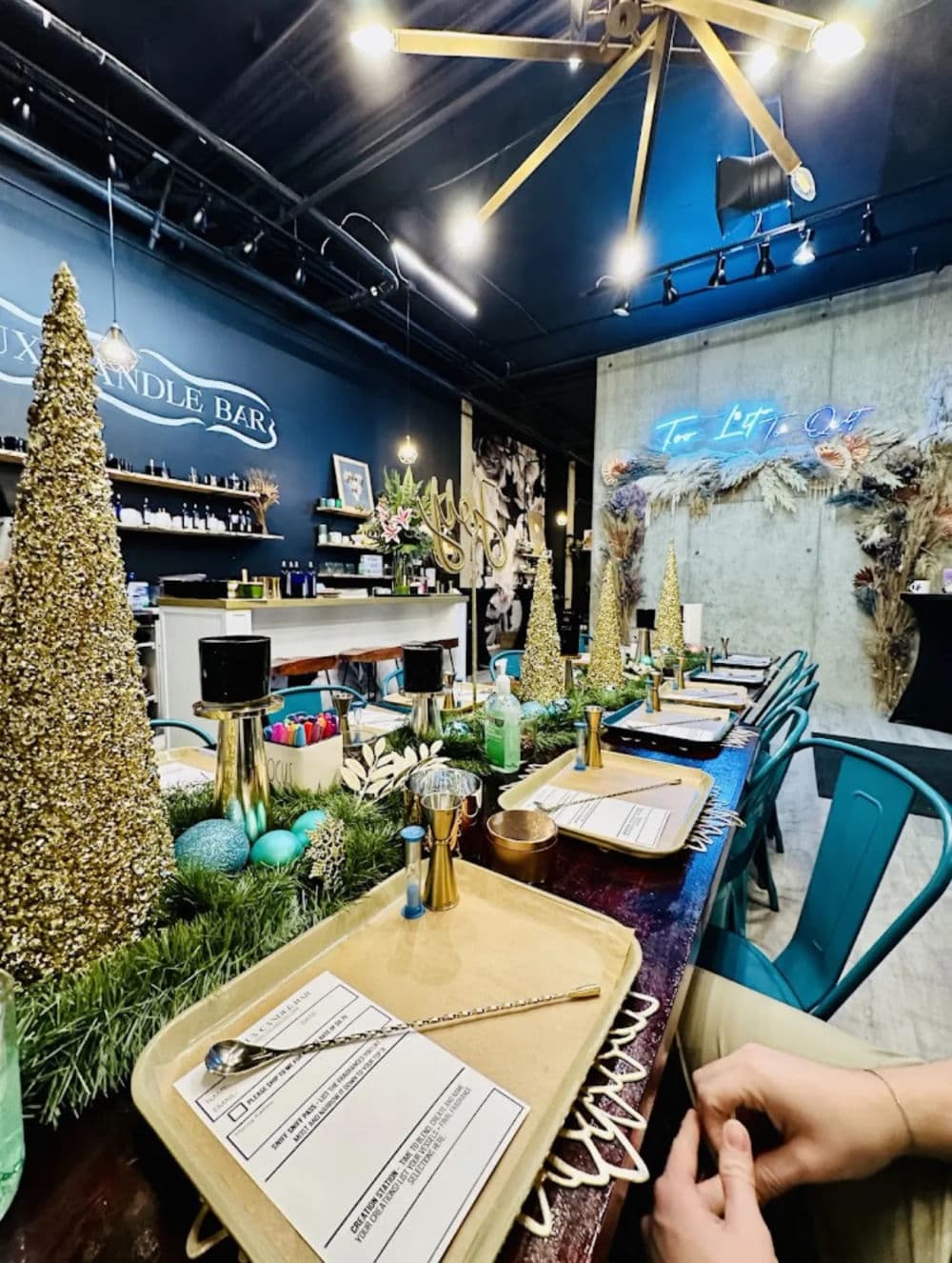 Luxurious candle-making bar with a festive setup, green decor, and colorful table arrangements.
