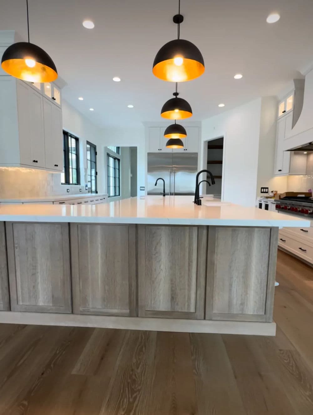 Modern kitchen with large island, pendant lights, and stylish cabinetry in neutral tones.